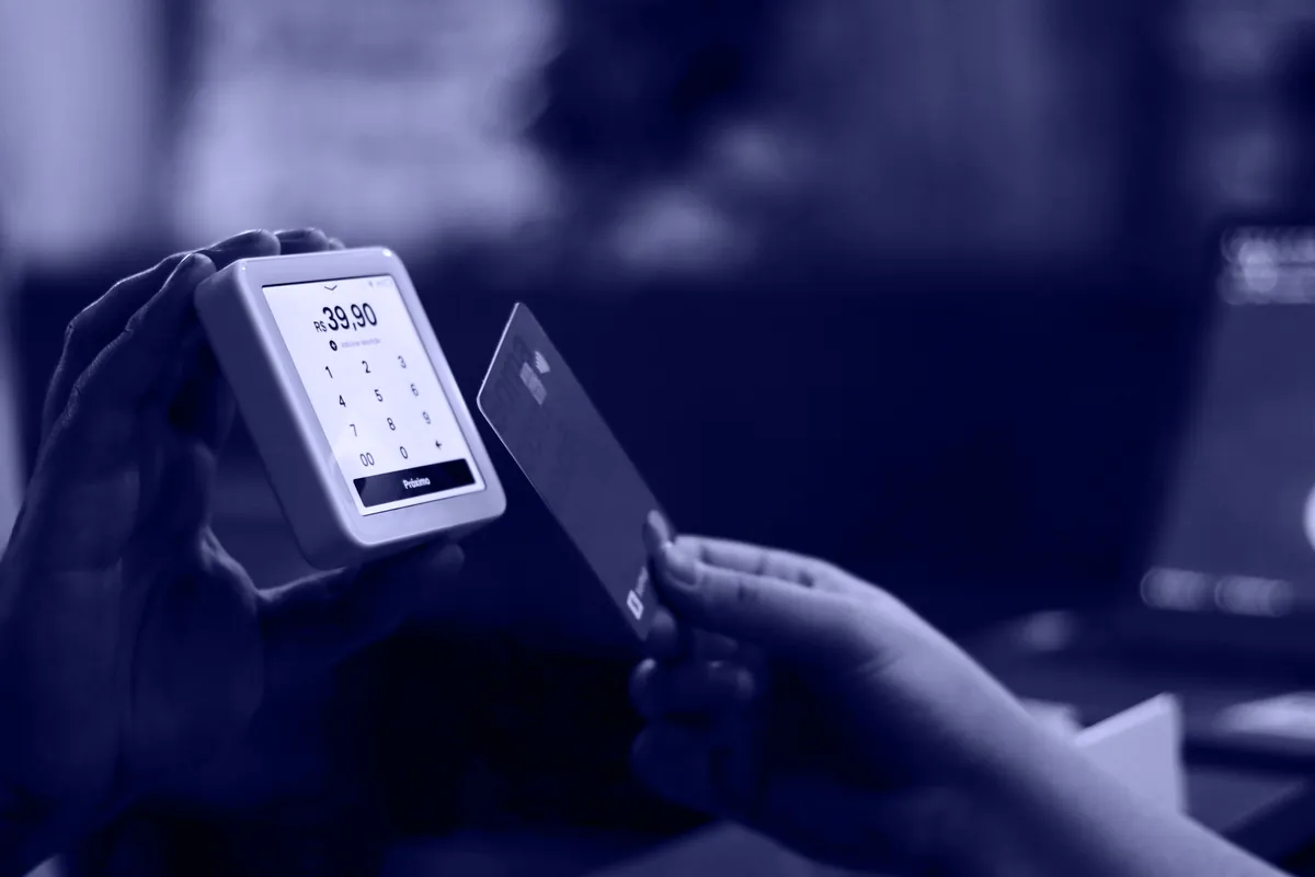 A hand tapping a card on a payment reader
